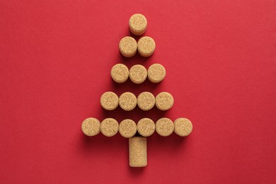 Christmas tree made of wine corks on red background, top view