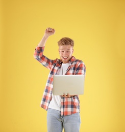 Photo of Emotional man with laptop on yellow background