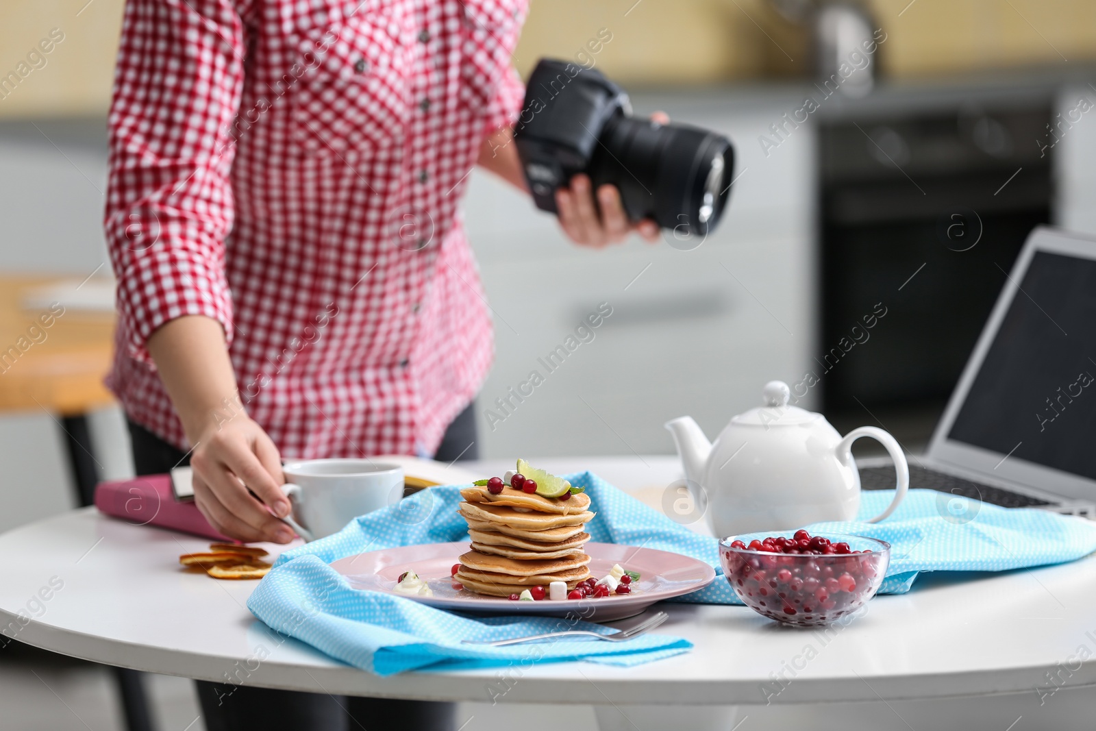 Photo of Food blogger taking photo of her breakfast at table, closeup