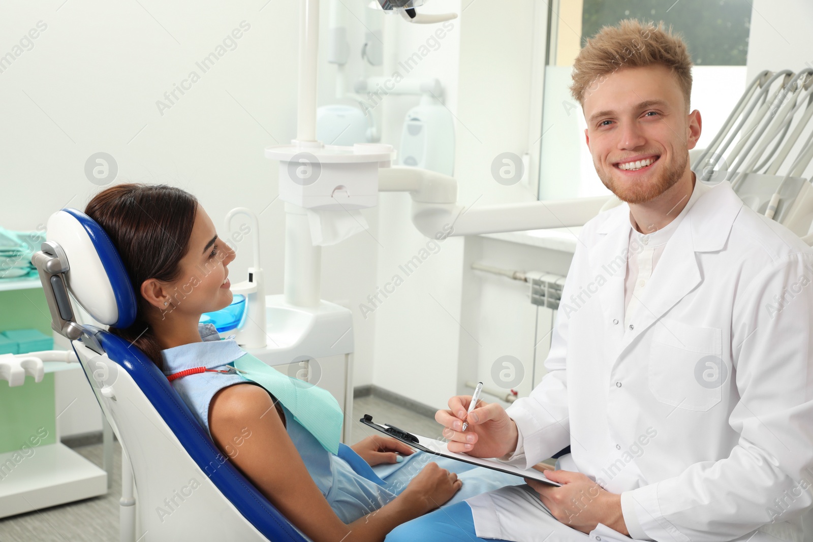 Photo of Professional dentist working with patient in clinic