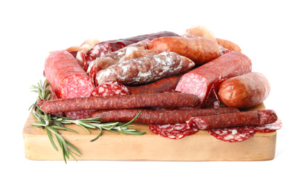 Different types of sausages with rosemary served on wooden board, white background
