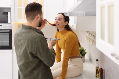 Lovely young couple cooking together in kitchen