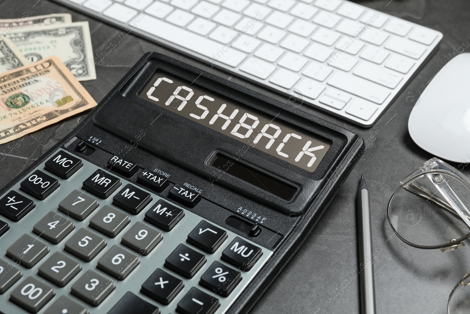 Image of Calculator with word Cashback, computer keyboard, glasses and money on dark table, closeup