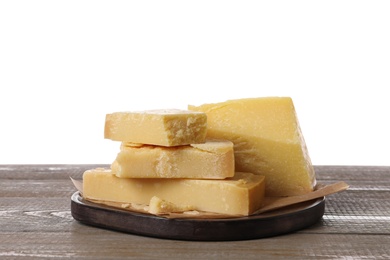 Pieces of delicious parmesan cheese on wooden table against white background