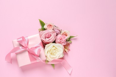 Photo of Gift box and beautiful flowers on pink background, flat lay. Space for text