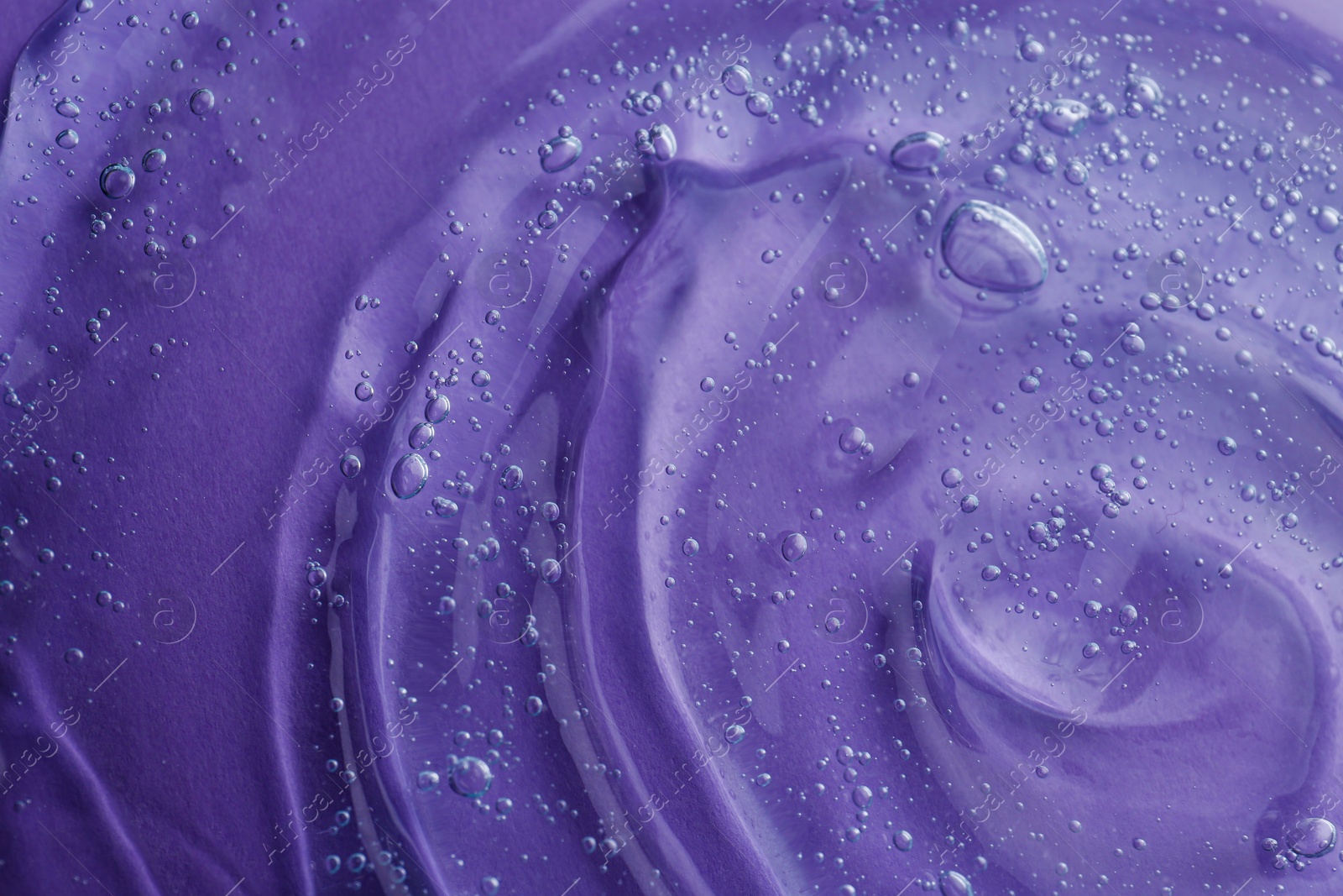 Photo of Transparent shower gel on violet background, closeup