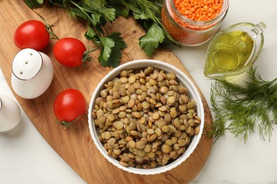 Photo of Delicious lentils in bowl served on table, flat lay