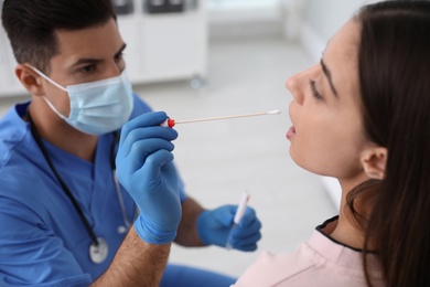 Doctor taking sample for DNA test from woman in clinic