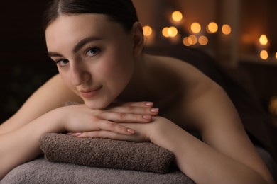 Spa therapy. Beautiful young woman lying on massage table in salon