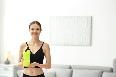 Athletic young woman with protein shake at home