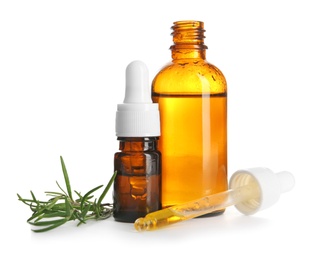 Photo of Different bottles with rosemary oil and fresh twig on white background