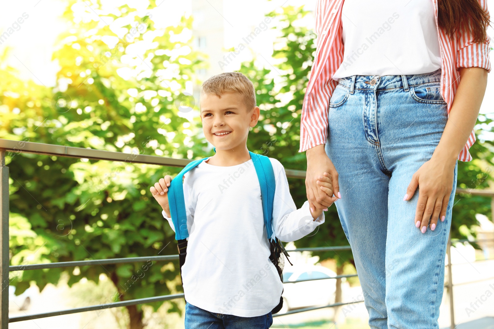 Image of Young mother taking her little child to school outdoors