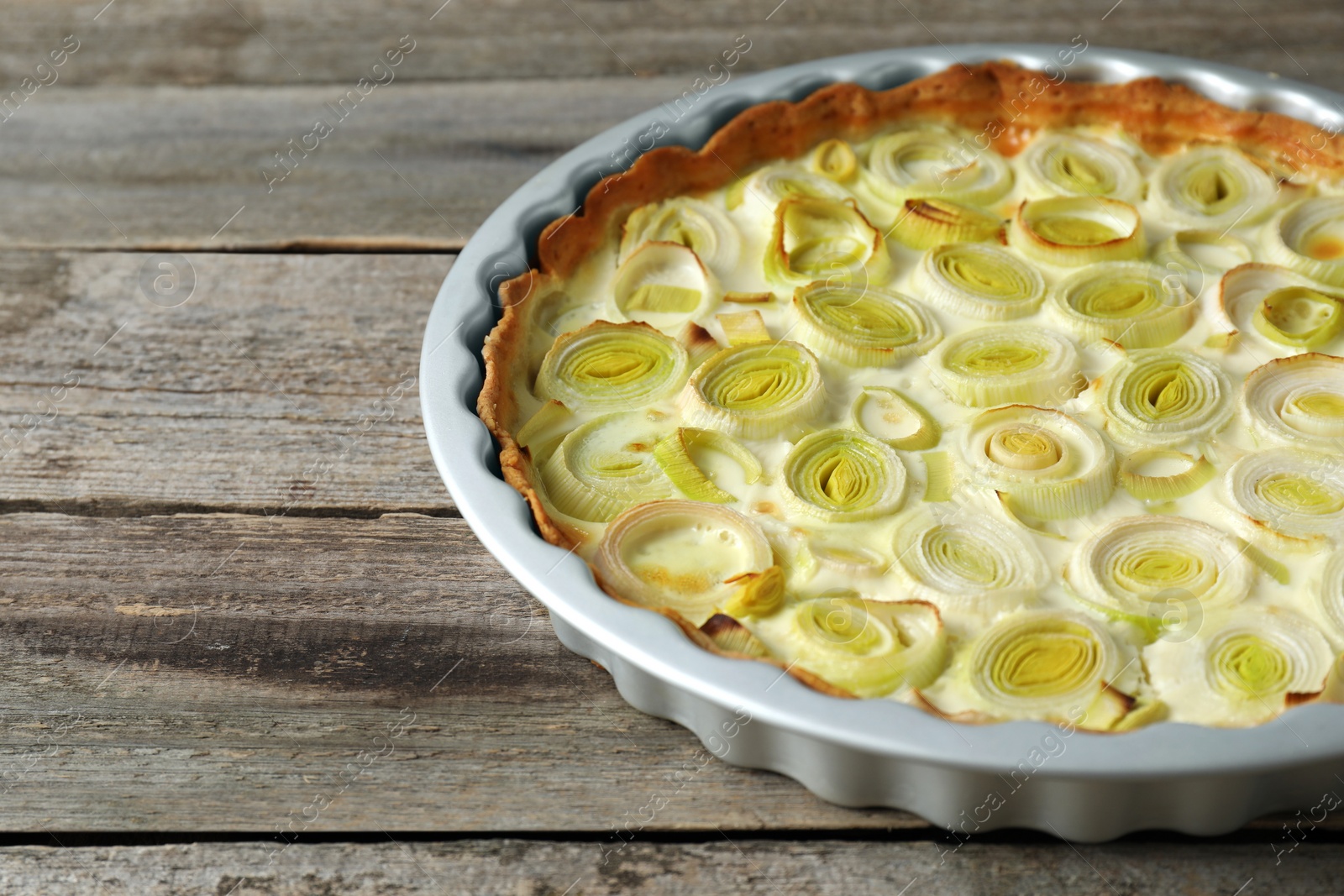 Photo of Tasty leek pie on old wooden table, closeup. Space for text