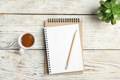 Photo of Flat lay composition with notebooks and coffee on wooden background