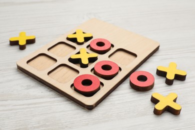 Tic tac toe set on white wooden table, closeup