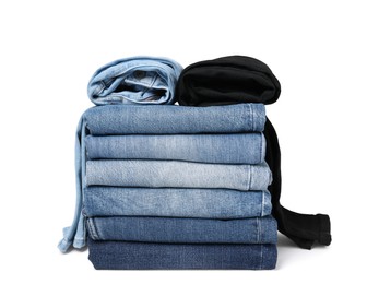 Stack of different folded jeans isolated on white