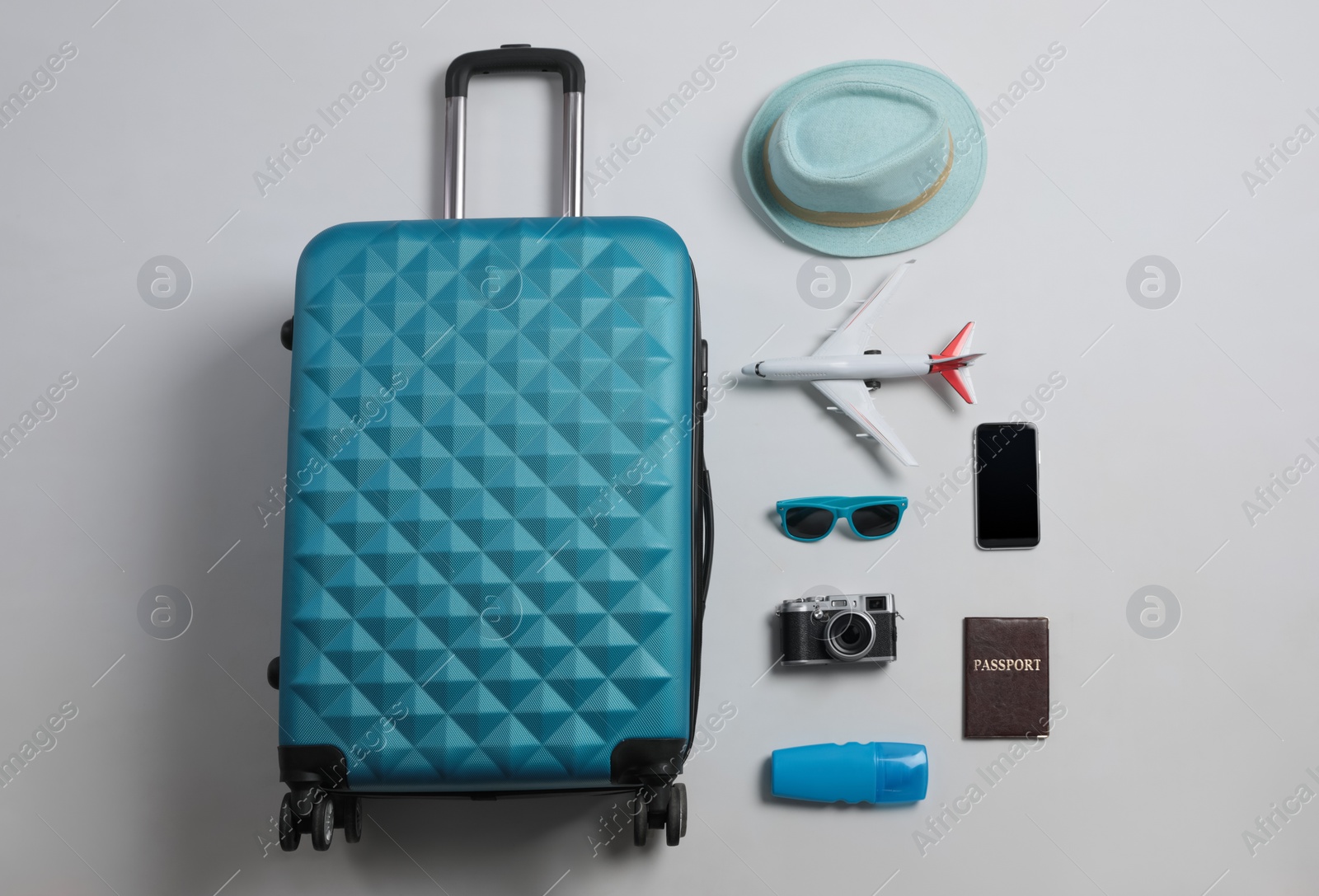 Photo of Flat lay composition with suitcase and travel accessories on grey background. Summer vacation