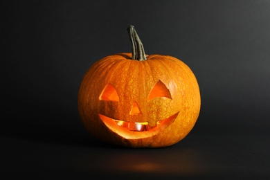 Photo of Halloween pumpkin head jack lantern on dark background