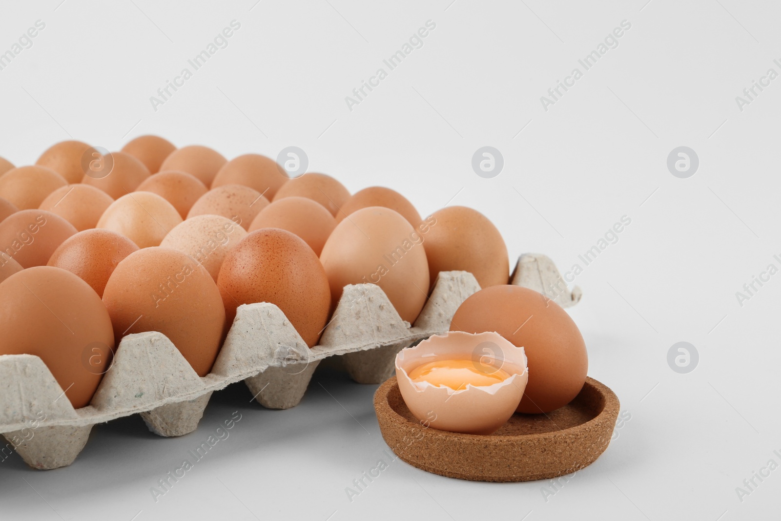 Photo of Raw brown chicken eggs on white background