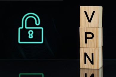 Acronym VPN (Virtual Private Network) made of wooden cubes on dark background. Space for text