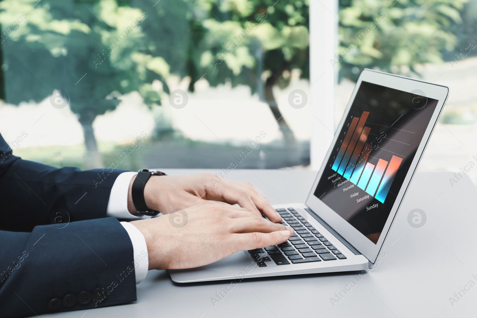 Image of  Broker working with laptop at table, closeup. Forex trading