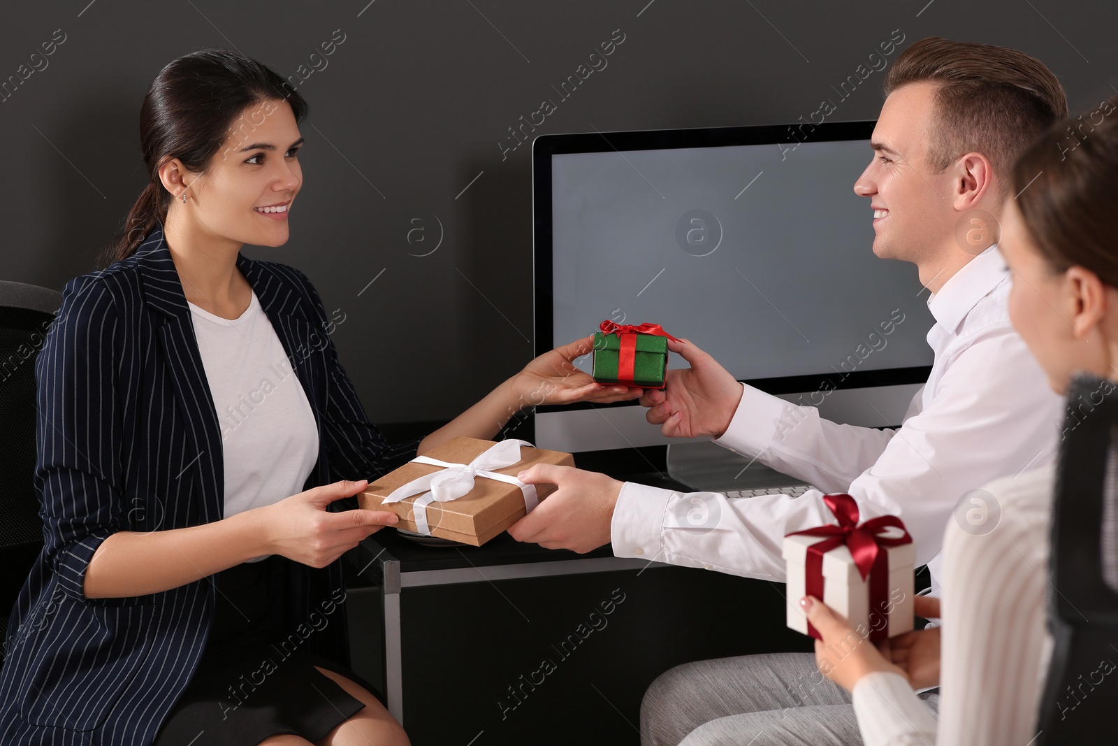 Photo of Colleagues presenting gifts each other in office