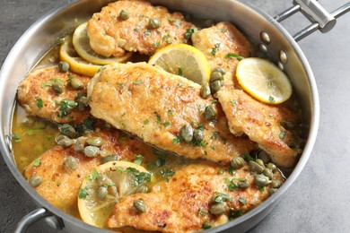 Photo of Delicious chicken piccata on grey table, closeup