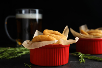 Photo of Fried onion rings served on black table