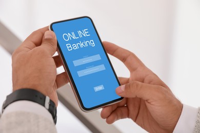 Image of Man using online banking application on smartphone indoors, closeup