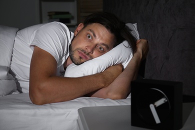 Photo of Man suffering from insomnia in bed at home