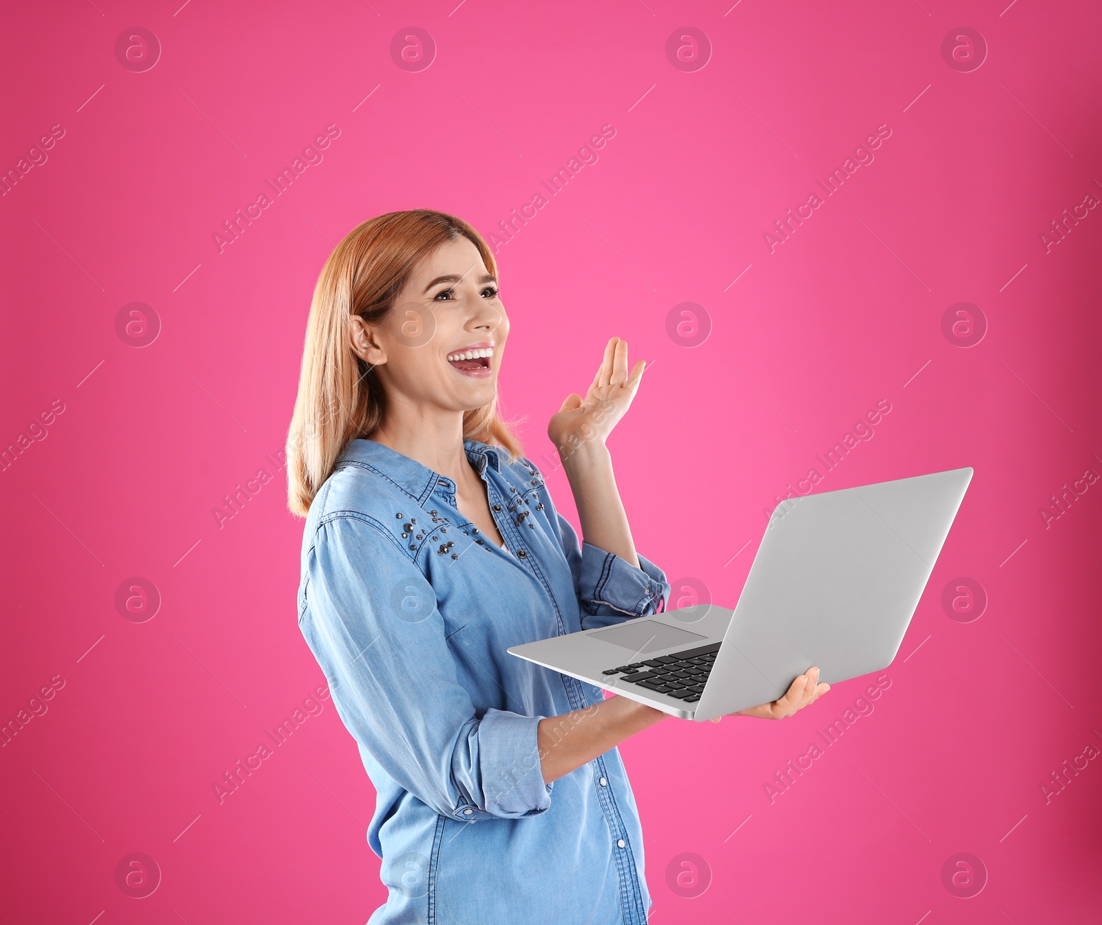 Photo of Woman using laptop for video chat on color background