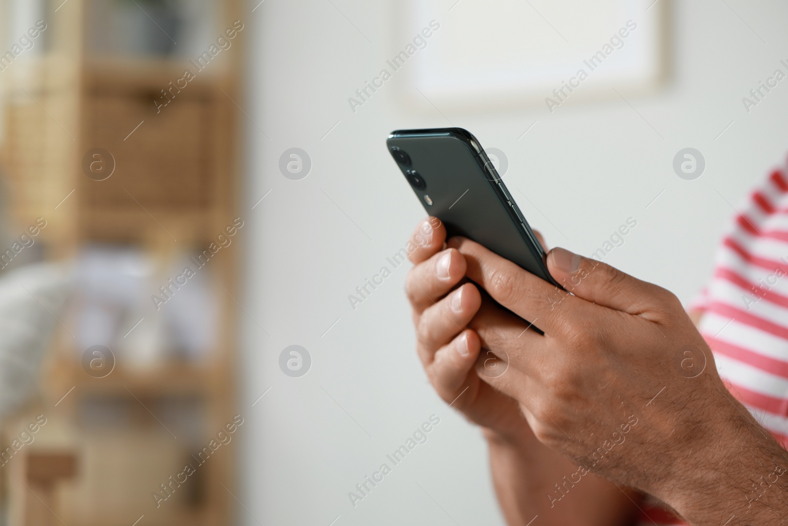 Photo of Man using smartphone at home, closeup view. Space for text