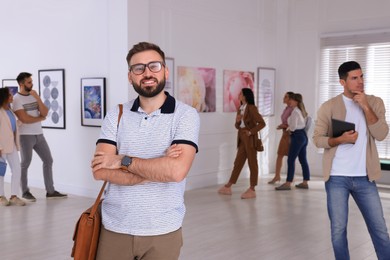 Photo of Happy young man at exhibition in art gallery