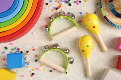 Photo of Baby song concept. Kids musical instruments and toys on beige carpet, flat lay