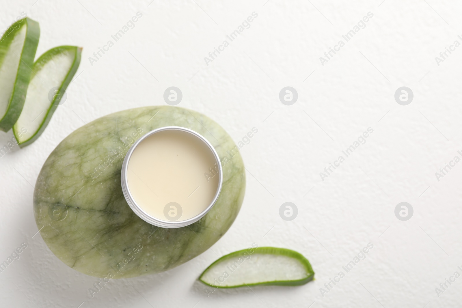 Photo of Lip balm and aloe vera plant on white background, flat lay. Space for text