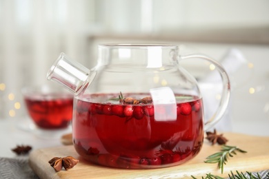 Photo of Tasty hot cranberry tea with rosemary and anise on table