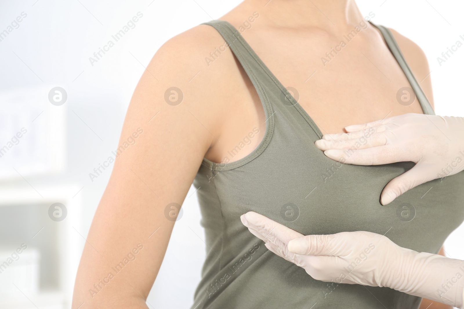 Photo of Doctor checking woman's breast at hospital, closeup