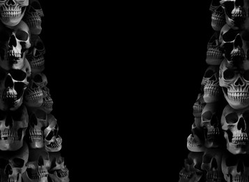 Image of Many scary human skulls on black background, space for text