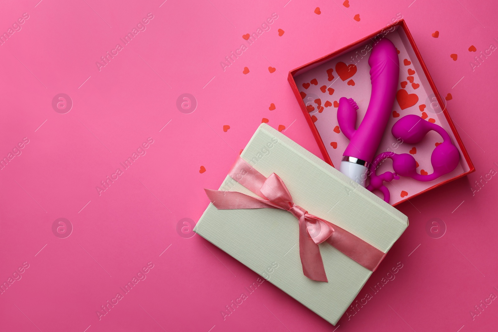 Photo of Gift box with sex toys on pink background, top view. Space for text