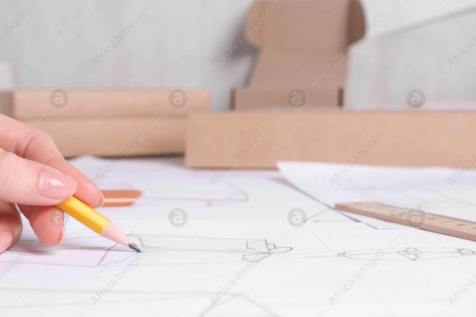 Photo of Woman creating packaging design at table, closeup