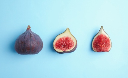 Photo of Delicious ripe figs on light blue background, flat lay