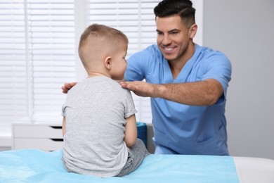 Orthopedist examining child in clinic. Scoliosis treatment