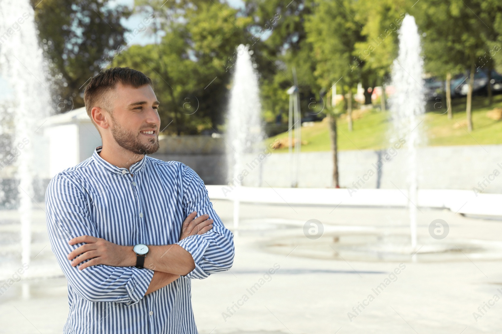 Photo of Portrait of handsome young man on street. Space for text