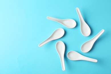 Miso soup spoons on blue background, flat lay. Space for text