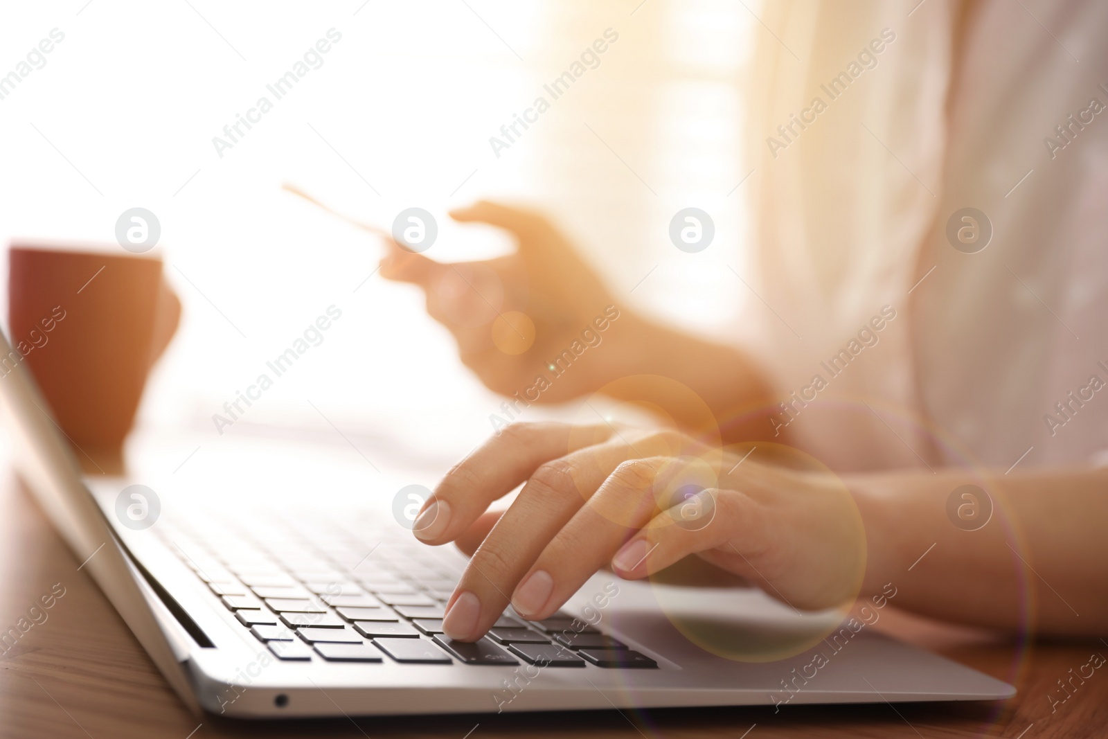 Image of Woman working with laptop at table indoors, closeup