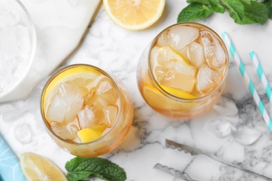 Photo of Delicious iced tea on white marble table, flat lay