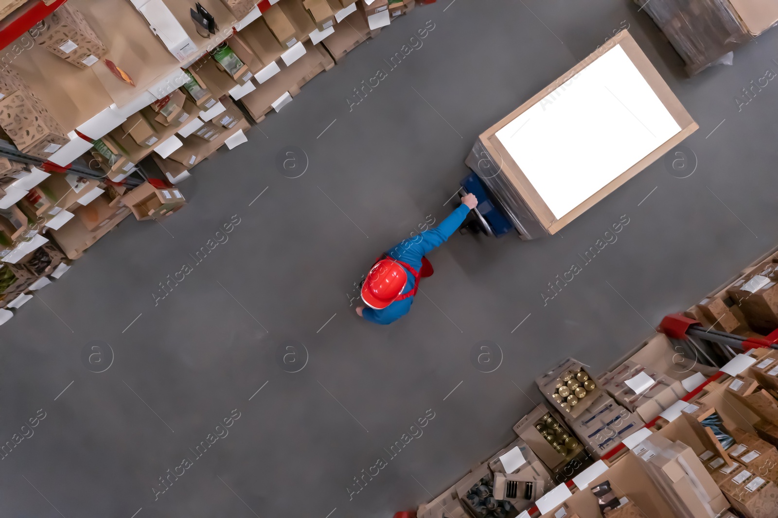 Image of Man working with pallet truck at warehouse, top view. Logistics center