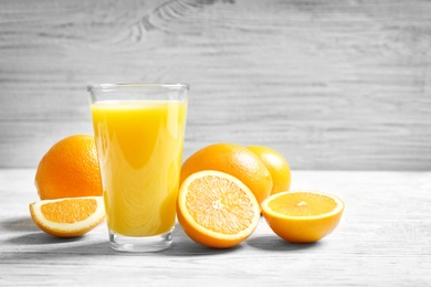 Photo of Glass of orange juice and fresh fruits on table