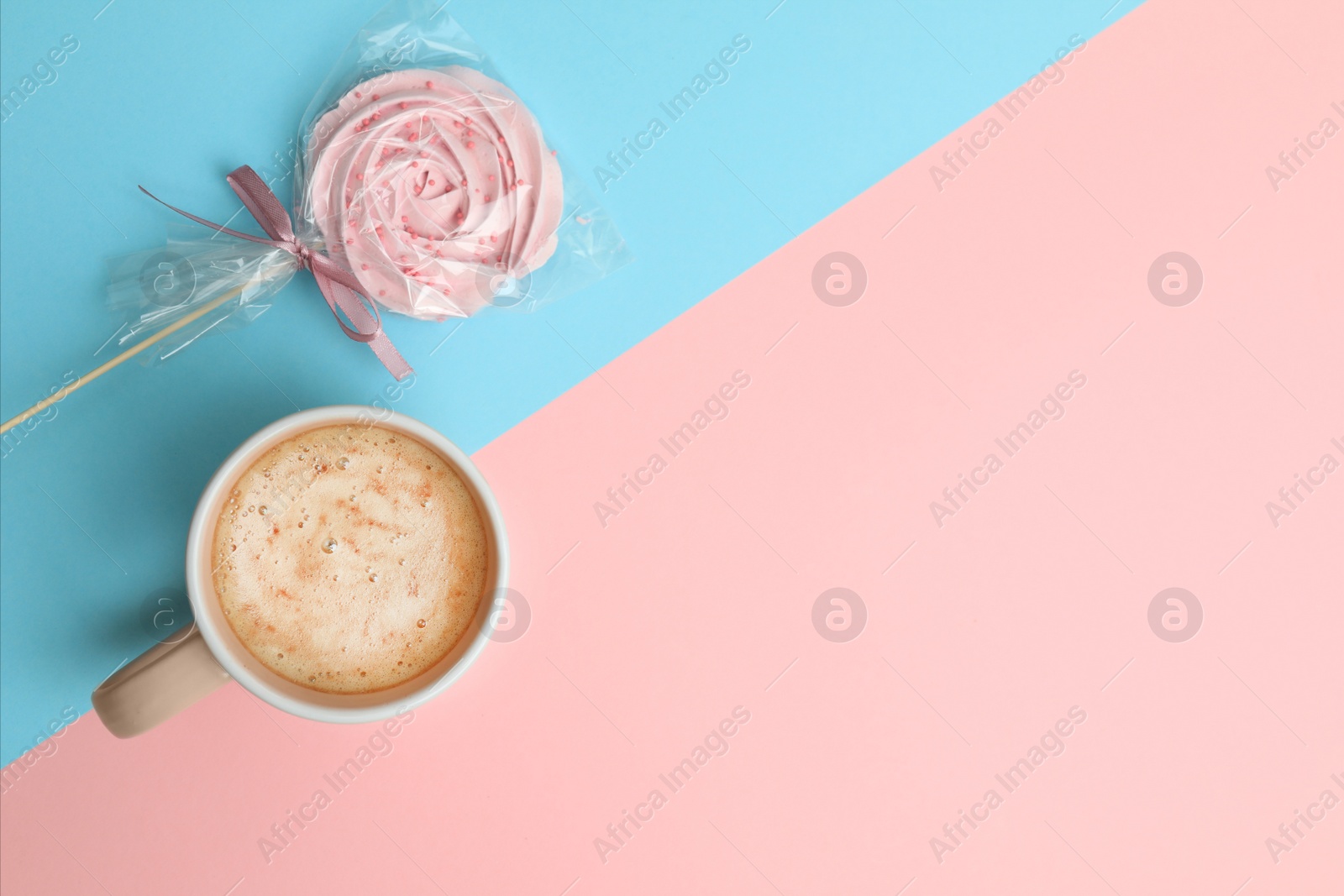 Photo of Cup of coffee and candy on color background, top view. Space for text