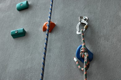 Photo of Colorful climbing wall with holds and ropes. Extreme sport
